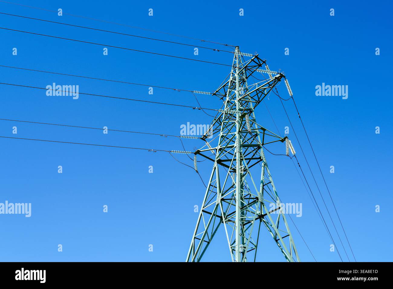Stahlgitter-Elektrizitätspylon mit mehreren Hochspannungskabeln und Keramikisolatoren Stockfoto