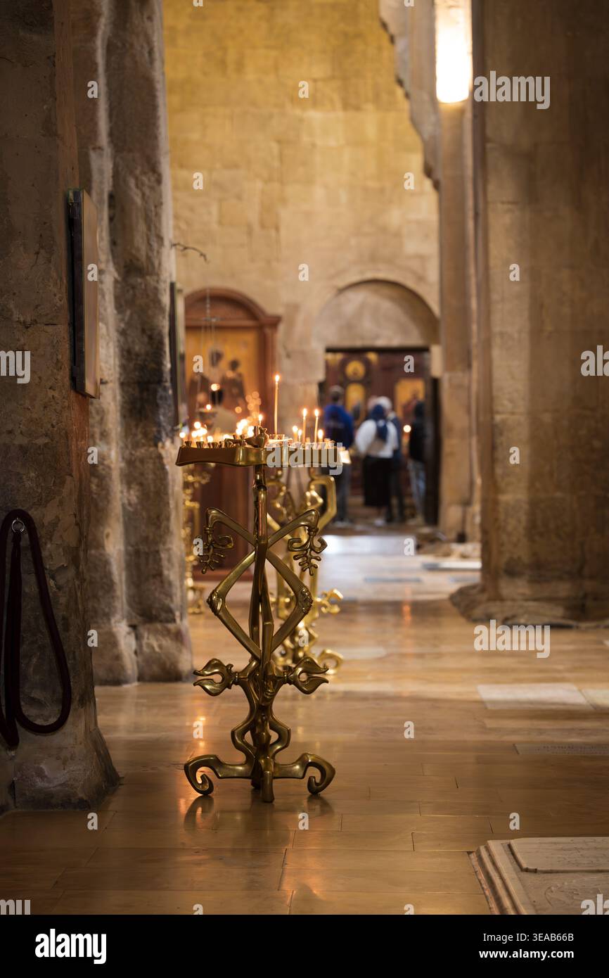 Blick auf das lange Schiff einer alten orthodoxen Kathedrale mit goldenen Kerzenständern und Ikonen Stockfoto