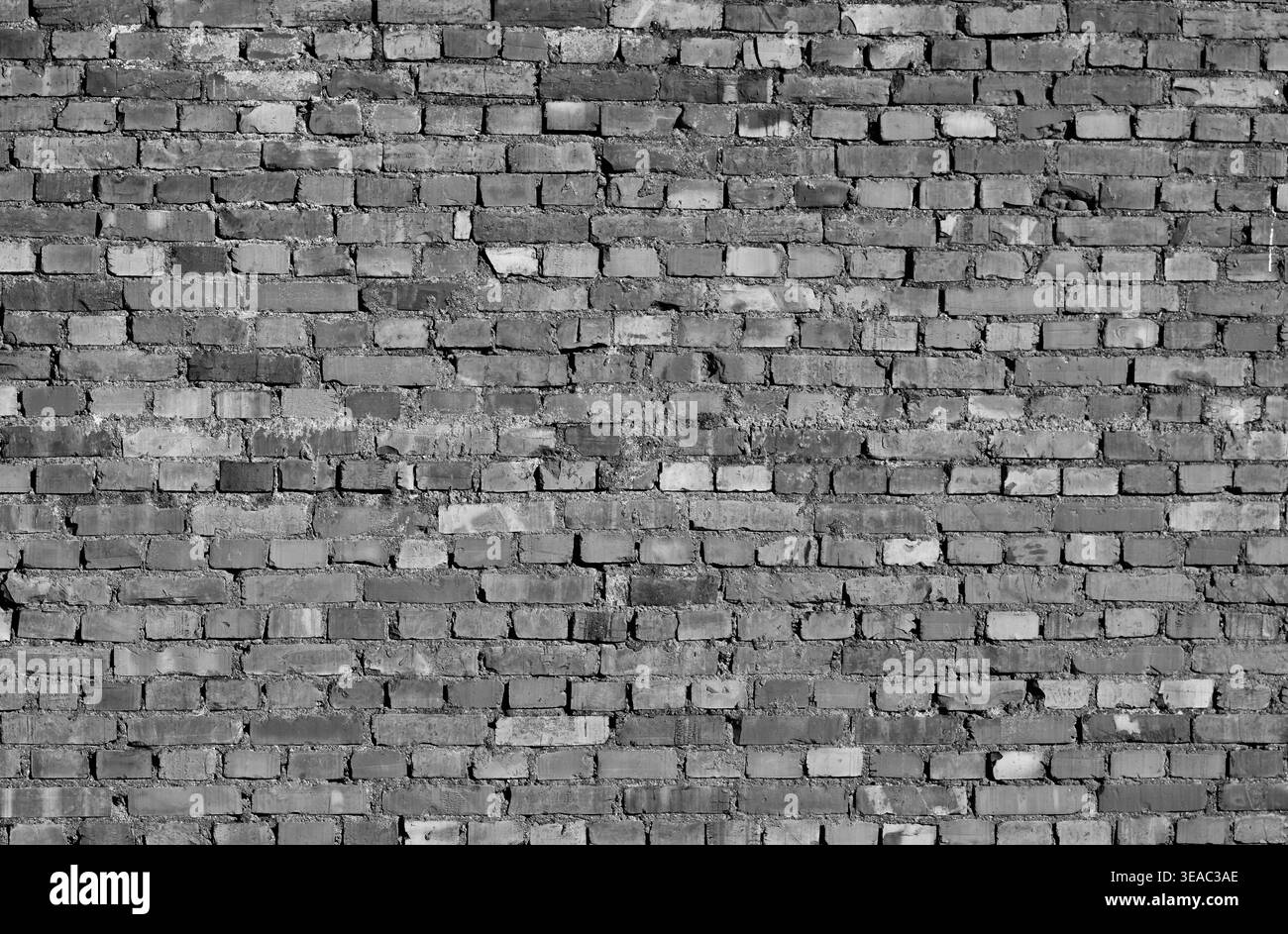 Schwarz-weiße Textur einer alten verwitterten Ziegelwand. Grungy industrieller Hintergrund, architektonisches Oberflächenmuster und Vintage-Mauerwerk. Hoch Stockfoto