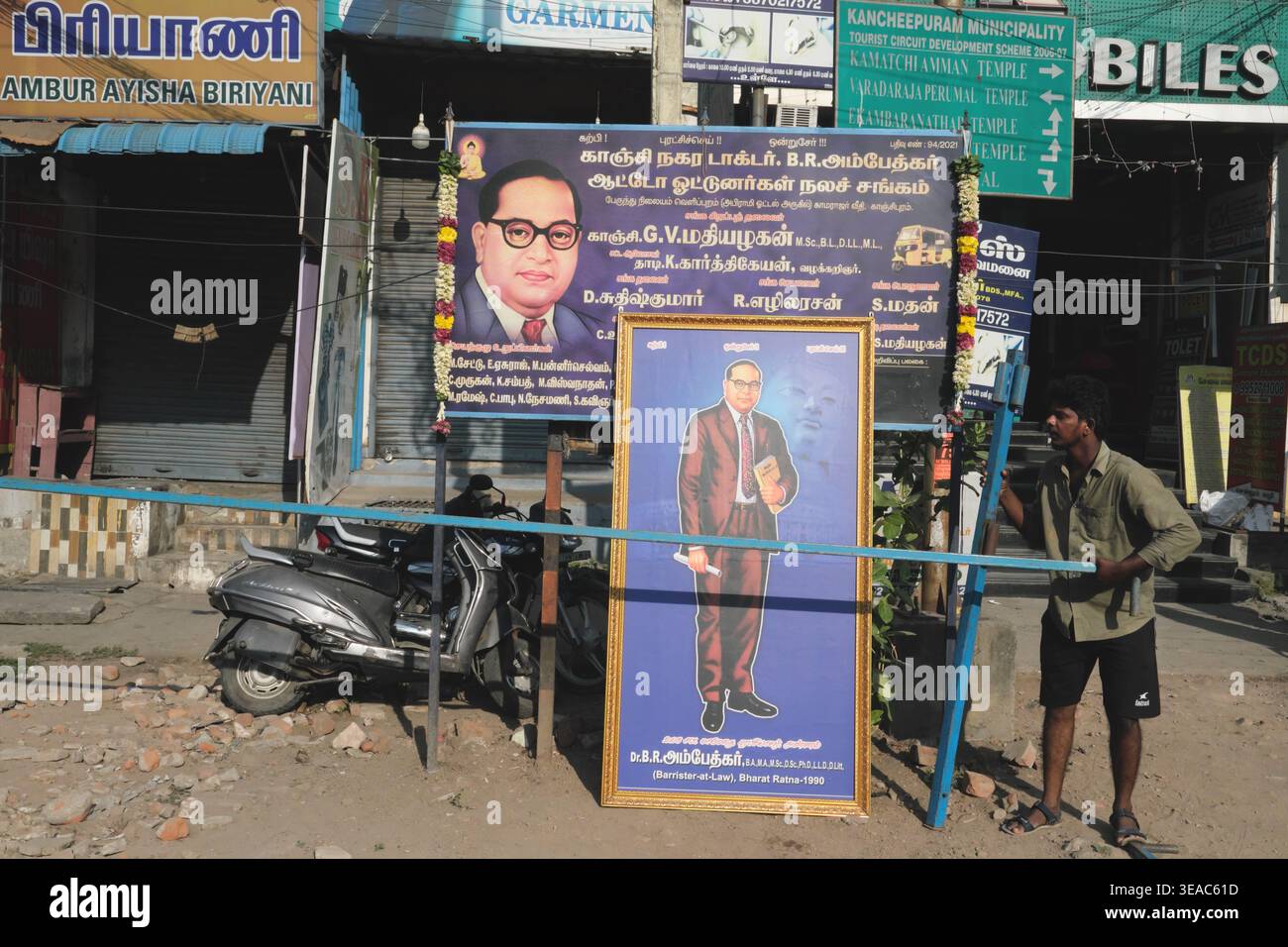 Ein tamilischer Mann steht neben Porträts von B.R. Ambedkar, indischem Reformator und Gründer einer neo-buddhistischen Bewegung; Kanchipuram, Tamil Nadu, Südindien Stockfoto