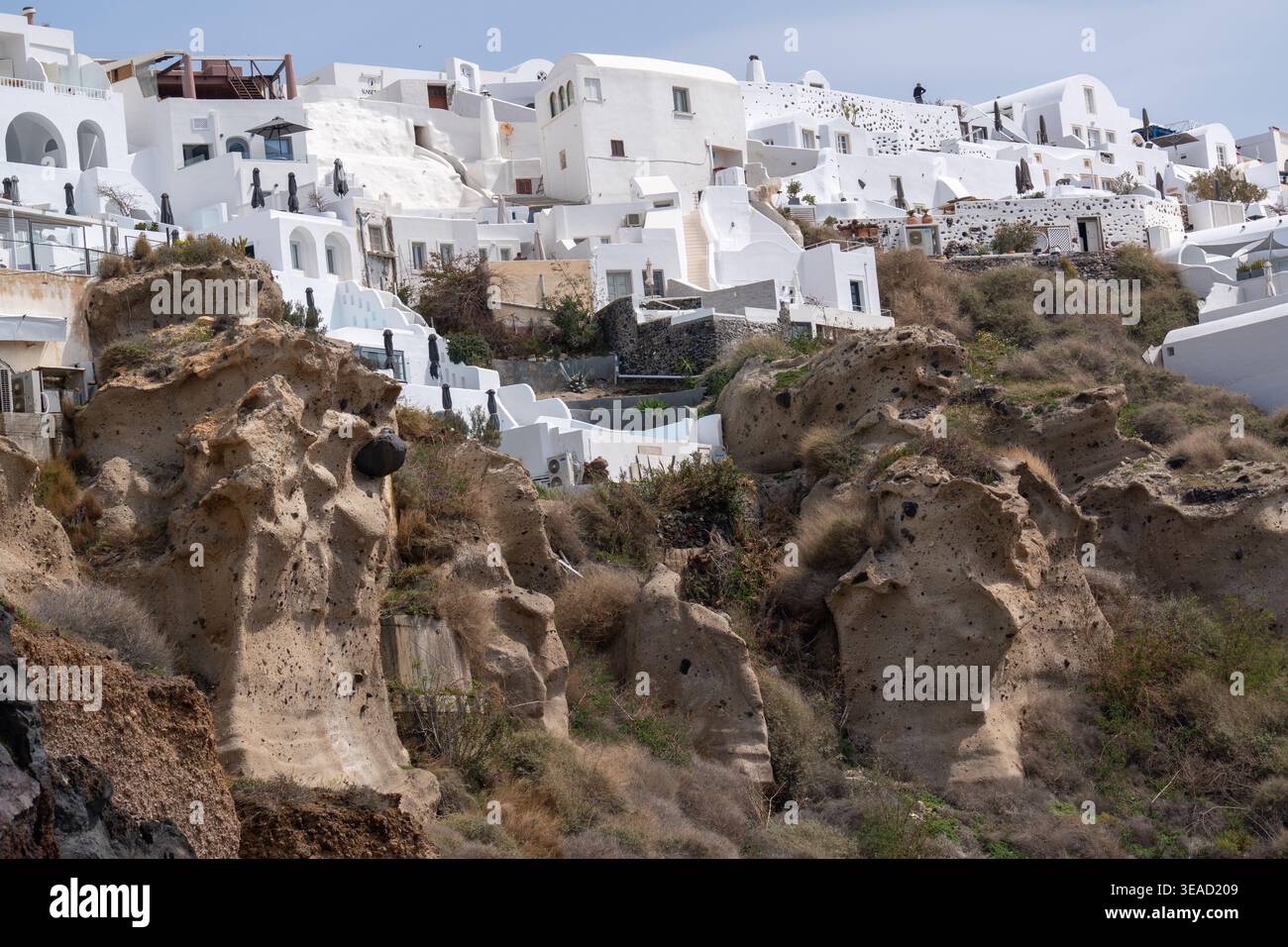 Vulkanische Felsformationen und Luxussuiten in Oia - Santorin. Stockfoto