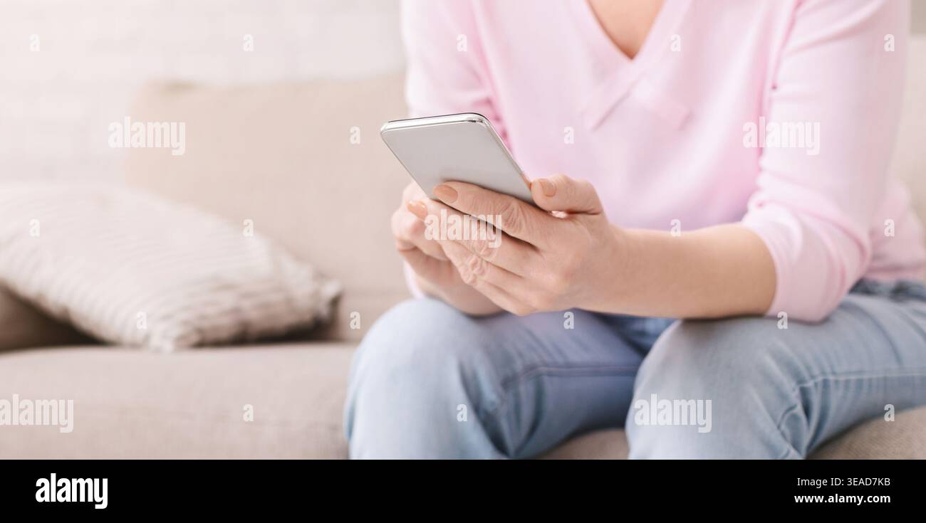 Active Senior Frau surfen auf modernen Smartphone Stockfoto