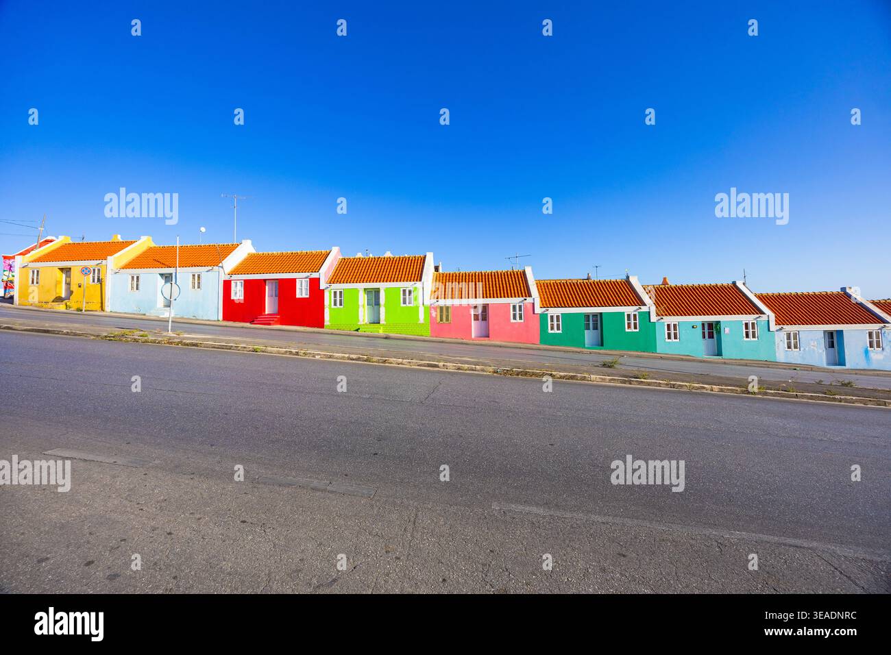Berühmte Regenbogenhäuser im Bezirk Berg Altena in Willemstad, Curacao, mit lebendiger Kolonialarchitektur unter klarem blauen Himmel Stockfoto