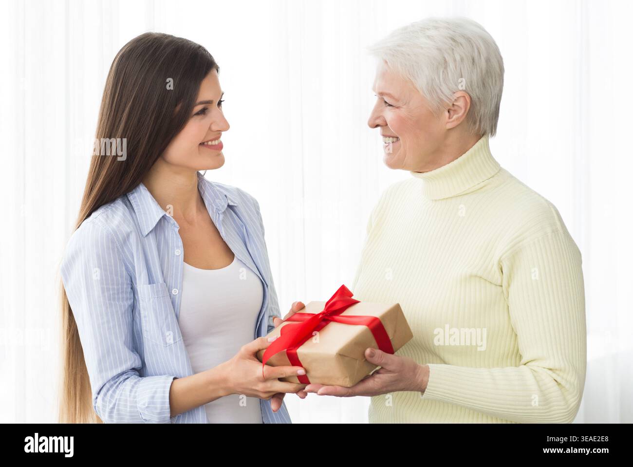 Ältere Mutter erhält Geschenk von erwachsener Tochter Stockfoto