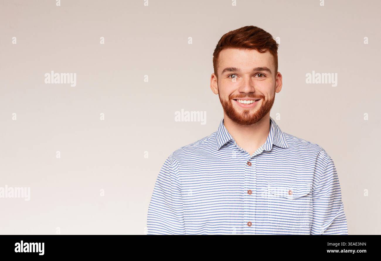 Portrait von lächelnden tausendjährigen Kerl auf beigen Hintergrund Stockfoto