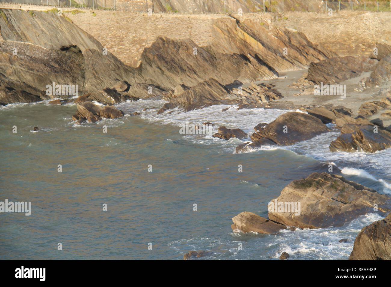 Felsen am Rande eines Küstenmeerestrandes. Stockfoto
