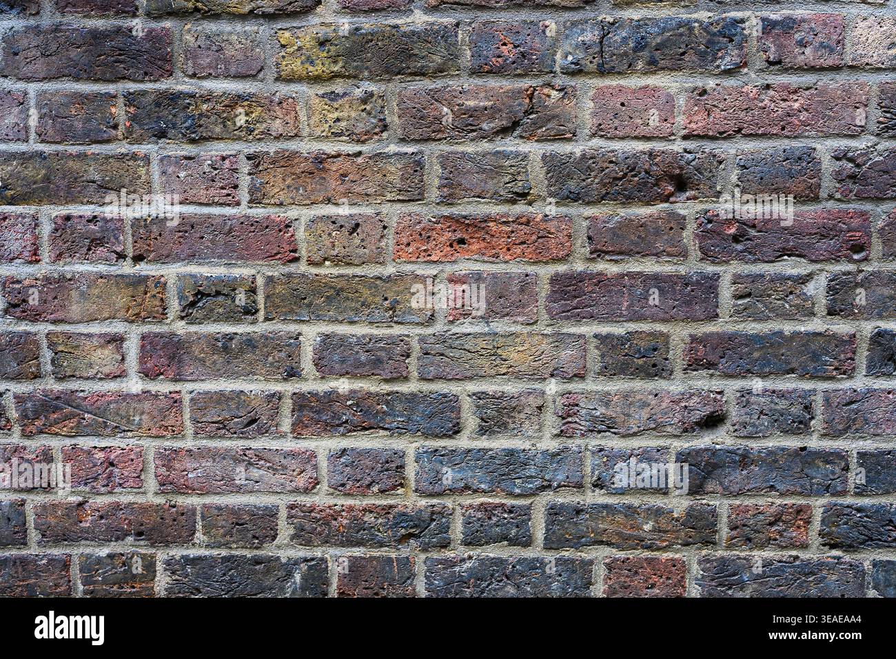 Verwitterte mehrfarbige raue Textur Backsteinwand Hintergrund mit Schmutz und Grim der Alterung Stockfoto