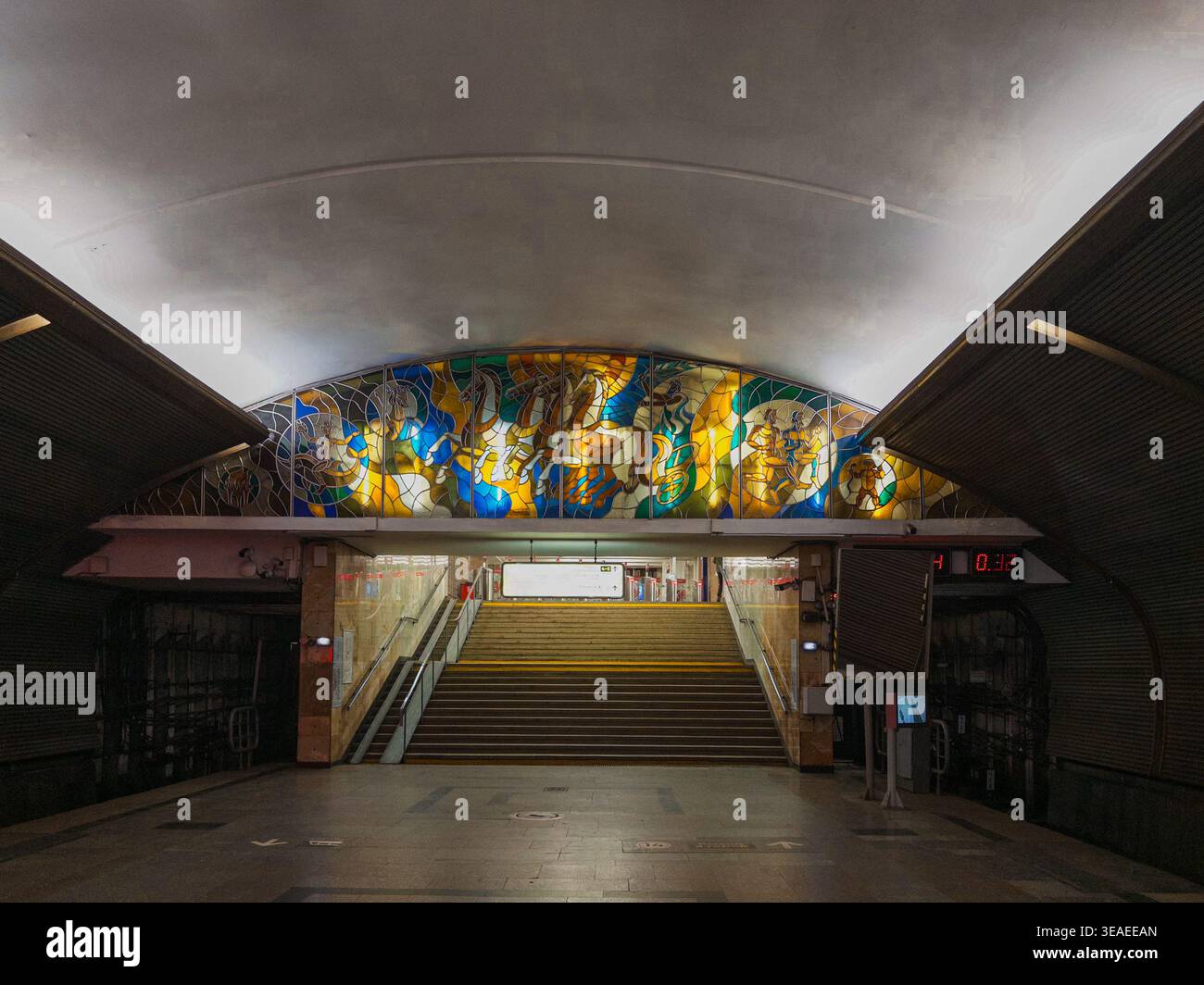 Buntglasfenster am Ende der Treppe in einem Eingang einer U-Bahn-Station, das wunderschöne unterirdische Architektur und öffentliche Kunst zeigt. - Smartphone-aufgenommenes Stockfoto