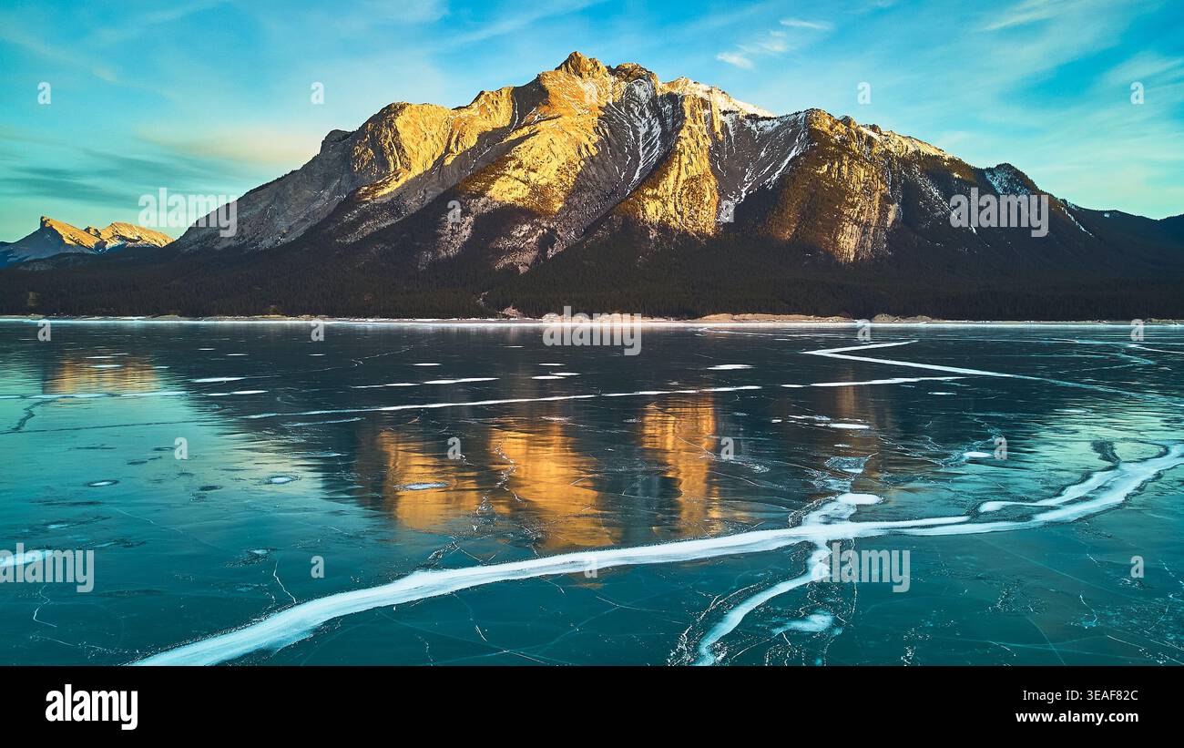 Frozen Lake und schneebedeckte Berge reflektieren bei Sonnenaufgang im Winter Stockfoto