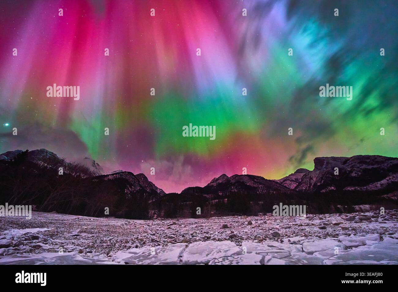 Nordlichter Über Gefrorenem See Mit Winterbergen Und Farbenfrohem Himmel Stockfoto