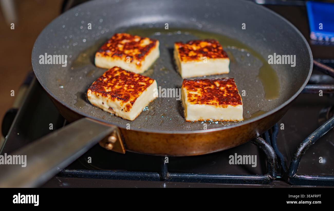 Quadrate von griechischem halloumi-Käse entwickeln beim Braten eine goldbraune Kruste Stockfoto