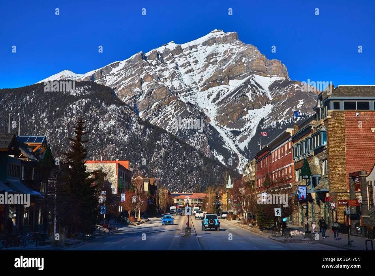 Banff Alberta Main Street Winter Town Scene mit schneebedeckten Bergen Hintergrund Stockfoto