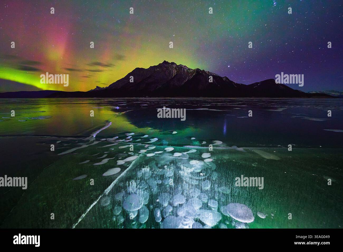 Nordlichter Über Gefrorenem See Mit Methan-Eisblasen Und Bergnachtslandschaft Stockfoto