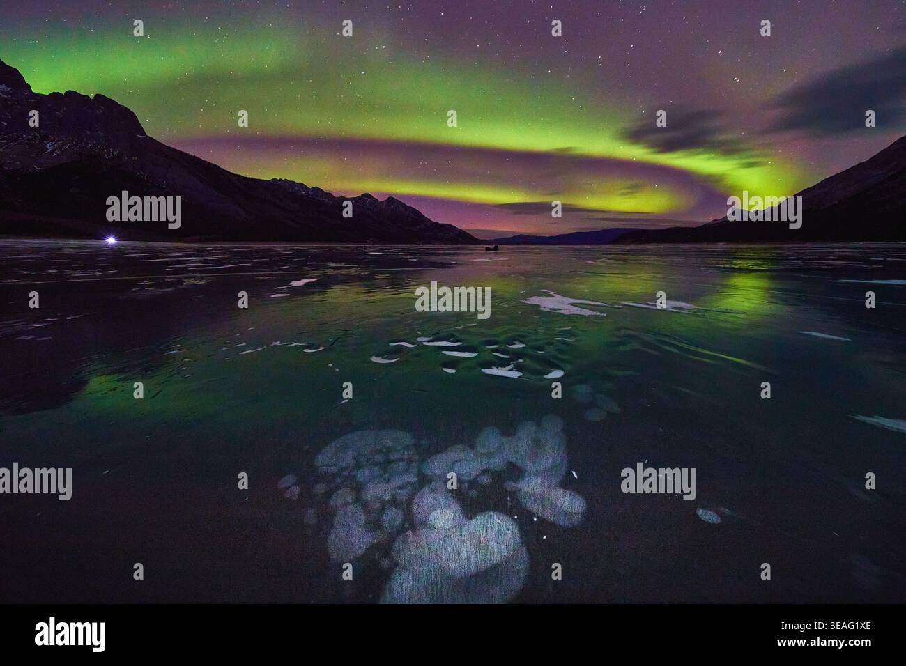 Nordlichter Über Dem Gefrorenen See Mit Eisblasen Und Mountain Silhouette Bei Nacht Stockfoto