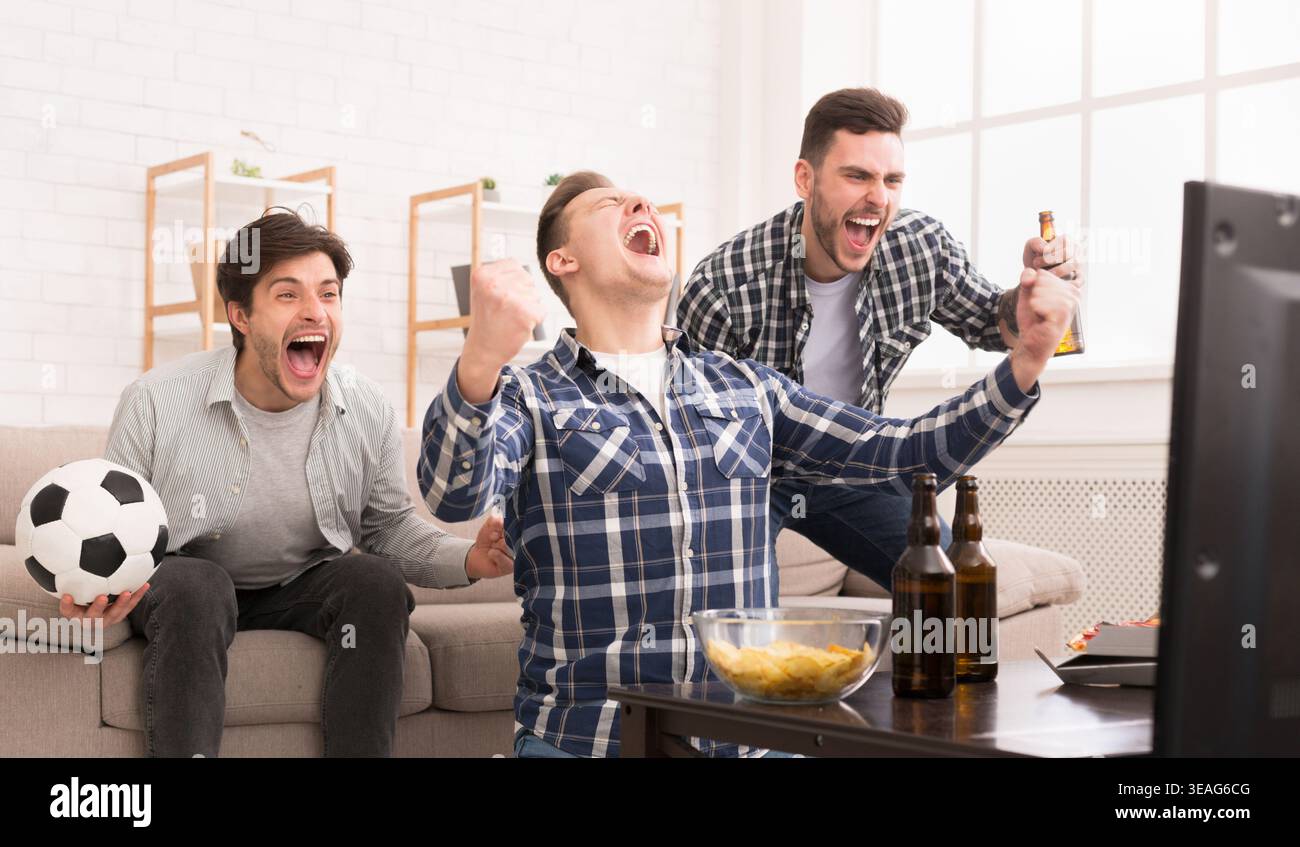 Sieger. Aufgeregt Freunde Fussball zu Hause beobachten Stockfoto