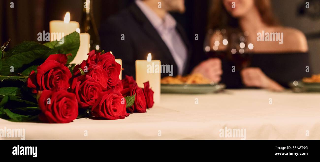 Ein romantisches Abendessen mit Rosen und Kerzen in gemütlicher Atmosphäre Stockfoto