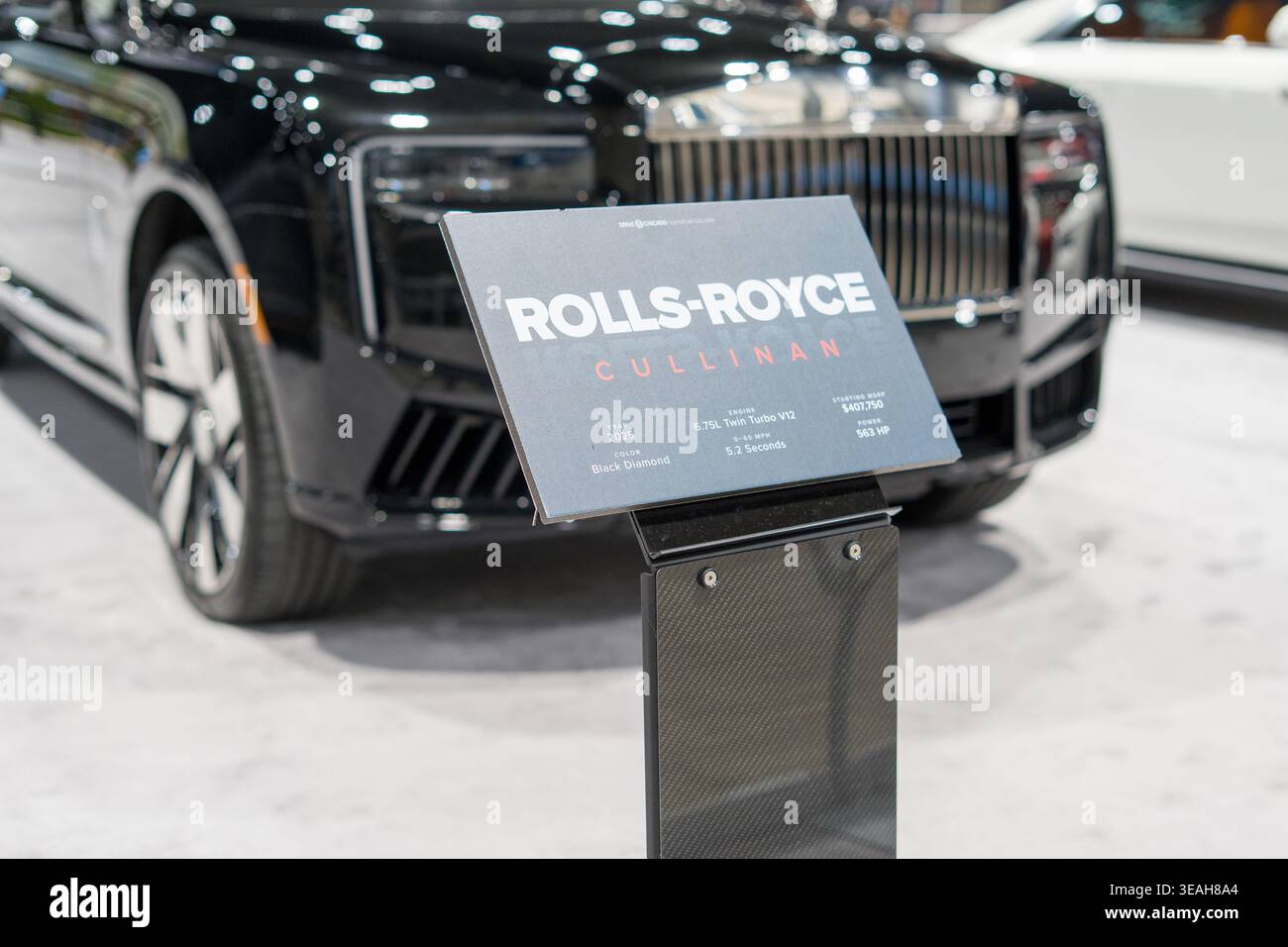 Chicago, IL, USA – 08. Februar 2026: Rolls-Royce Cullinan Luxus-SUV-Schild mit schwarzem Fahrzeug im Hintergrund auf der Chicago Auto Show. Stockfoto