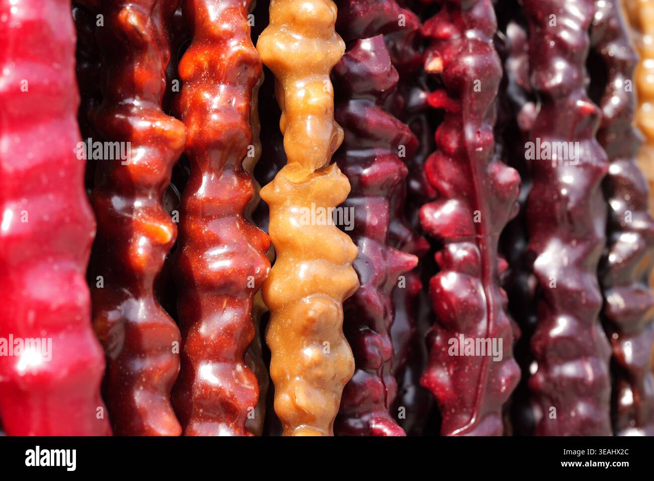 Lebendige Nahaufnahme von hängendem Traubensaft und Nussbonbons in verschiedenen Geschmacksrichtungen und Farben Stockfoto