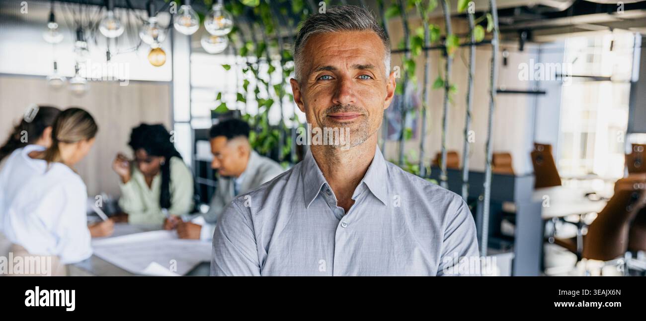 Professionell mit freundlichem Ausdruck, der die Teamarbeit überwacht Stockfoto
