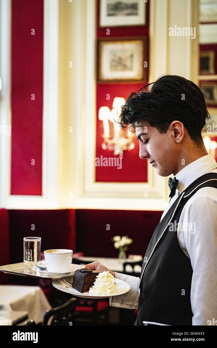 Junge Kellner servieren Original Sacher Kuchen, Cafe Sacher, Inneneinrichtung, Kaffeekultur in Wien, Österreich Stockfoto
