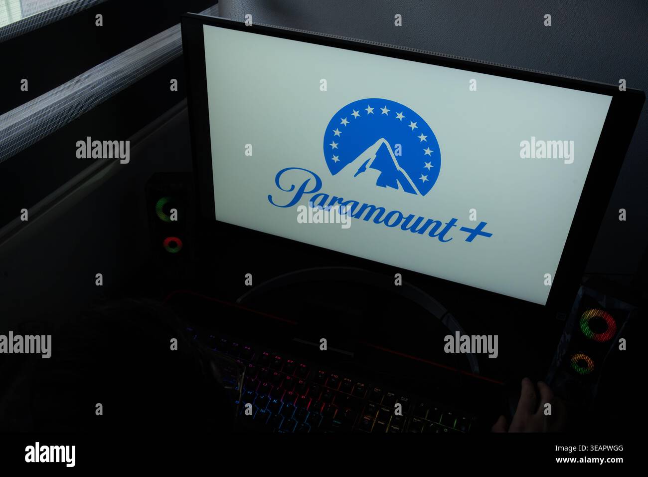 Das Logo des Paramount+-Streaming-Dienstes wird auf einem Computermonitor in einer dunklen Home-Office-Umgebung angezeigt Stockfoto