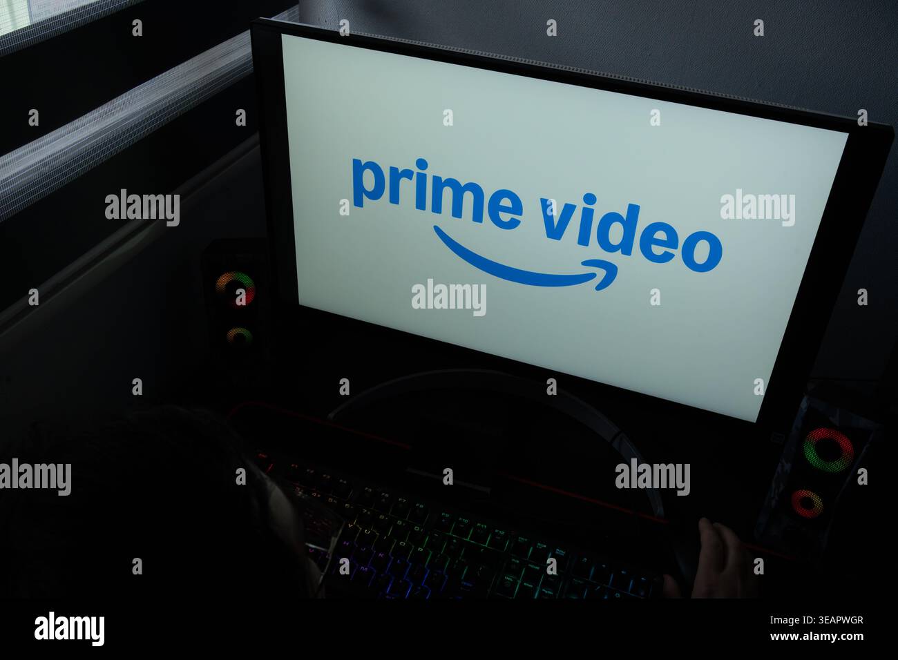 Das Amazon Prime Video-Logo und das Pfeilsymbol werden auf einem Computermonitor in einem dunklen Raum angezeigt Stockfoto