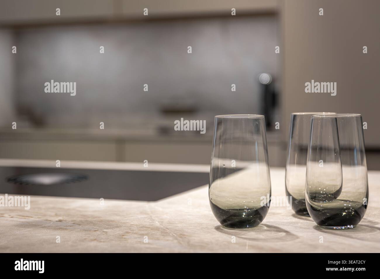 Moderne Gläser auf einer Steinküche. Stilvolle Details einer hochwertigen Kücheneinrichtung. Stockfoto