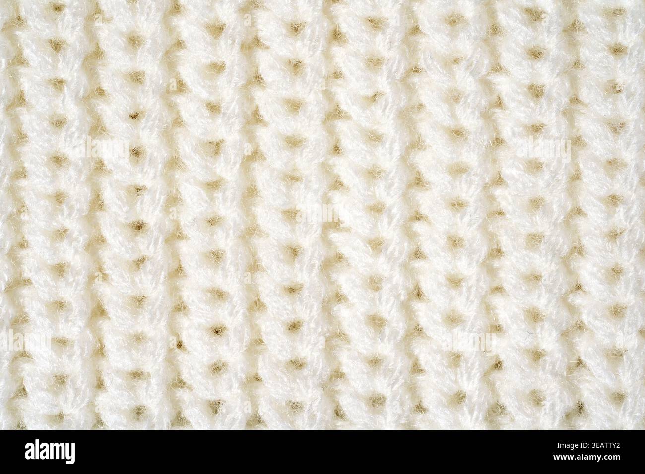Close-up-Pullover-Textur in weiß-Elfenbein, Makrogestrick-Oberfläche und Kunstfaser-Details. Konzept des taktilen Textilmaterials, praktisch Easy-c Stockfoto