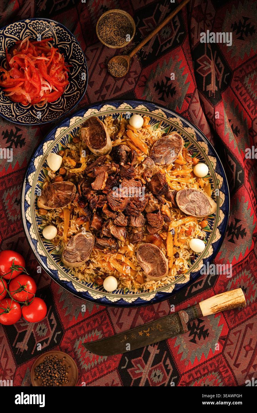 Lammreis-Festmahl. Rustikale usbekische Mahlzeit mit Gewürzen und Gemüse Stockfoto