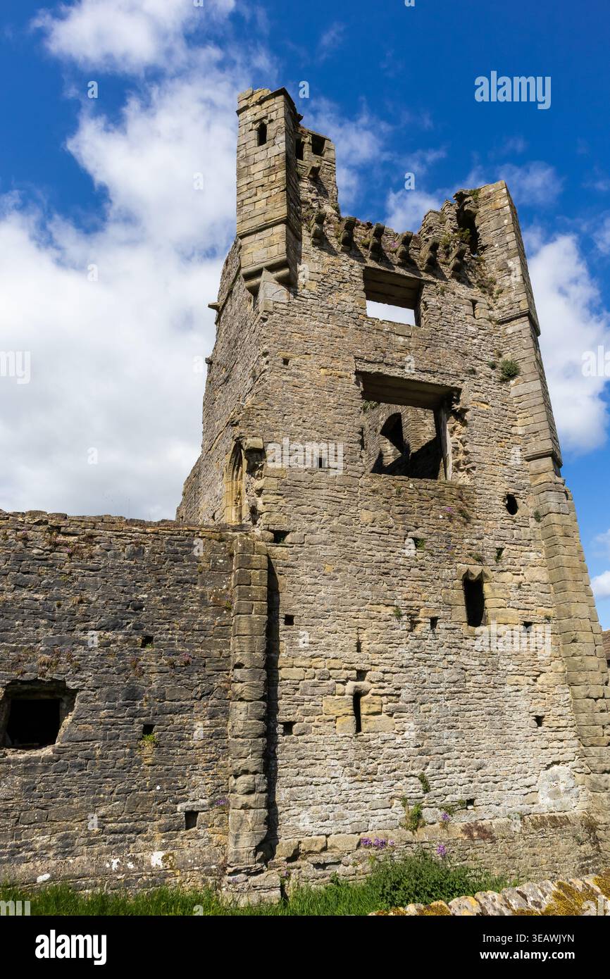 Ruine des Turms von Middleham Castle, der sich gegen einen blauen Himmel mit Kumuluswolken erhebt Stockfoto