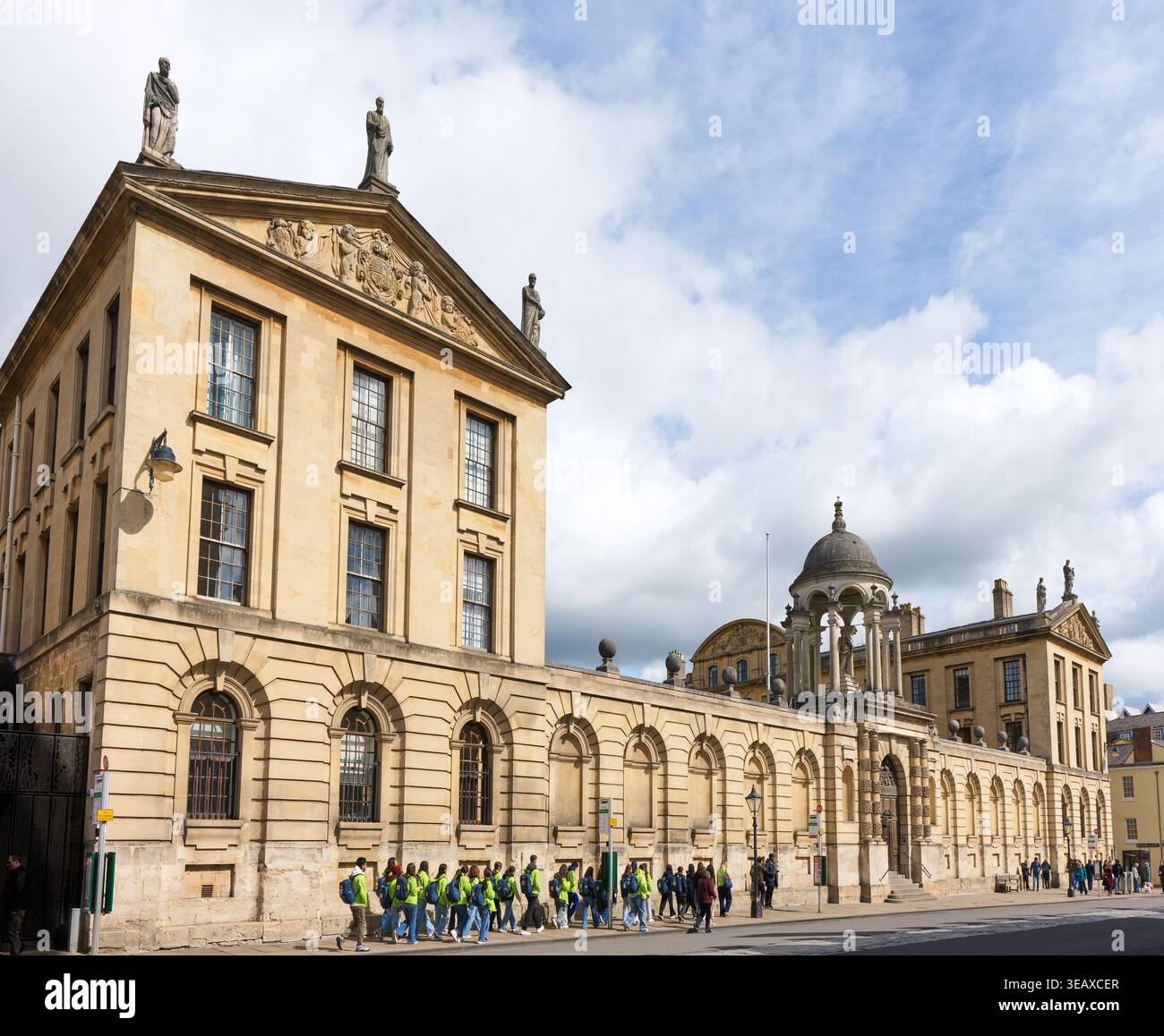 Eine Gruppe von Schulkindern spaziert vorbei am Queen's College, University of Oxford, England. Stockfoto