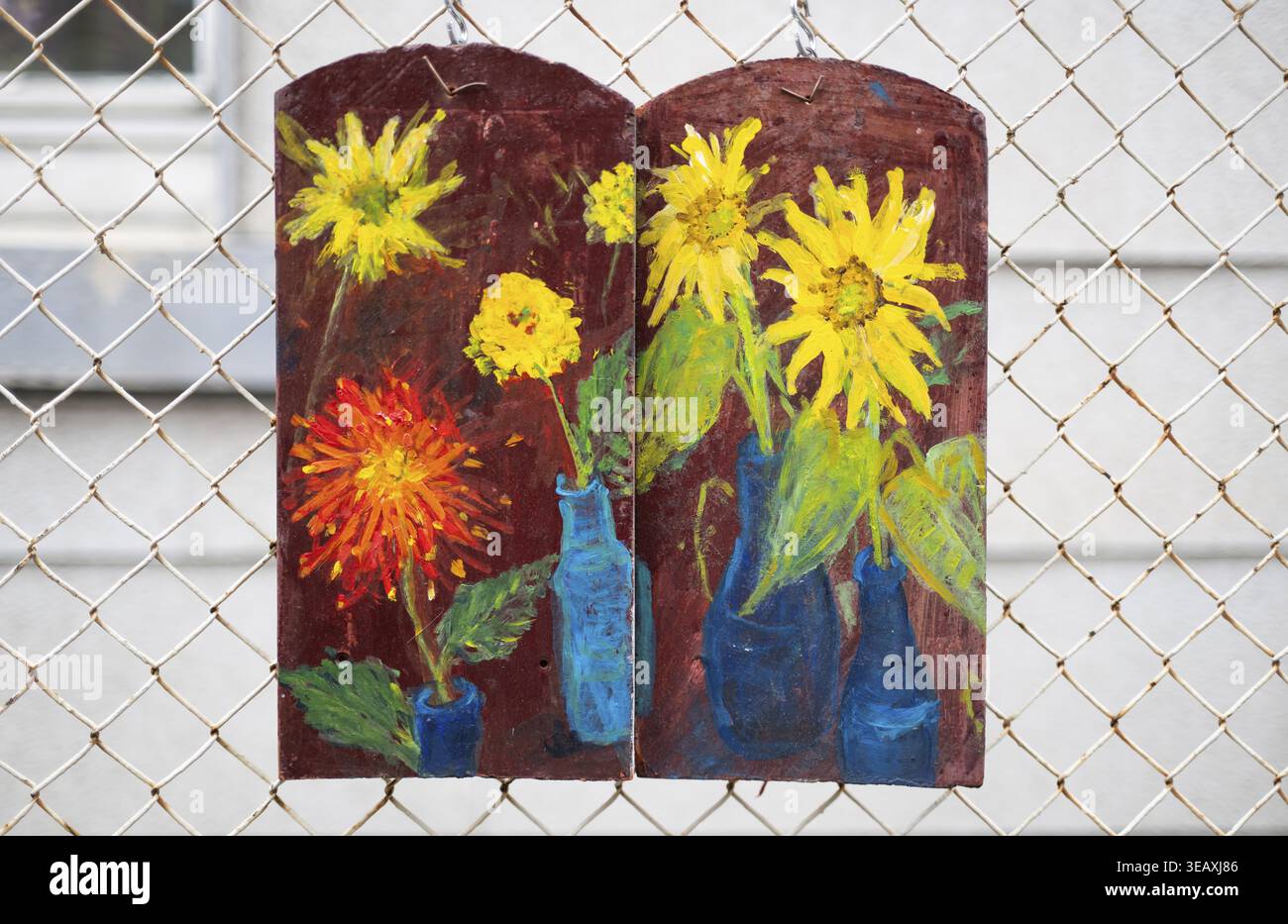 Dachziegel mit Blumen und Vasen, die an einem Maschendrahtzaun hängen, Stuttgart, Baden-Württemberg, Deutschland Stockfoto