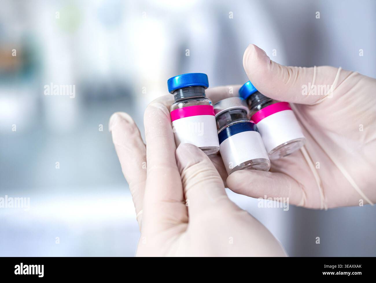 Nahaufnahme der Hand-Hand-Impfstoffglasflaschen zur Injektion. COVID 19 Corona Virus 2019-ncov. Durchstechflaschen für den medizinischen Impfstoff mit weißem, leerem Etikett in Stockfoto