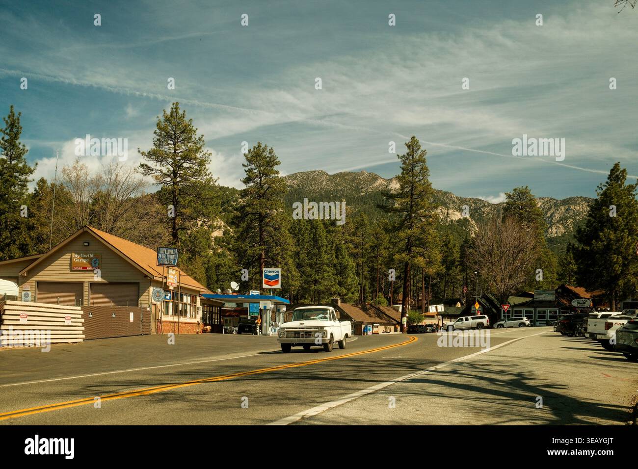 Straßenszene in Idyllwild, Kalifornien, mit alten weißen Trucks, Kleinstädten und Kiefern in einer Berglandschaft. Stockfoto