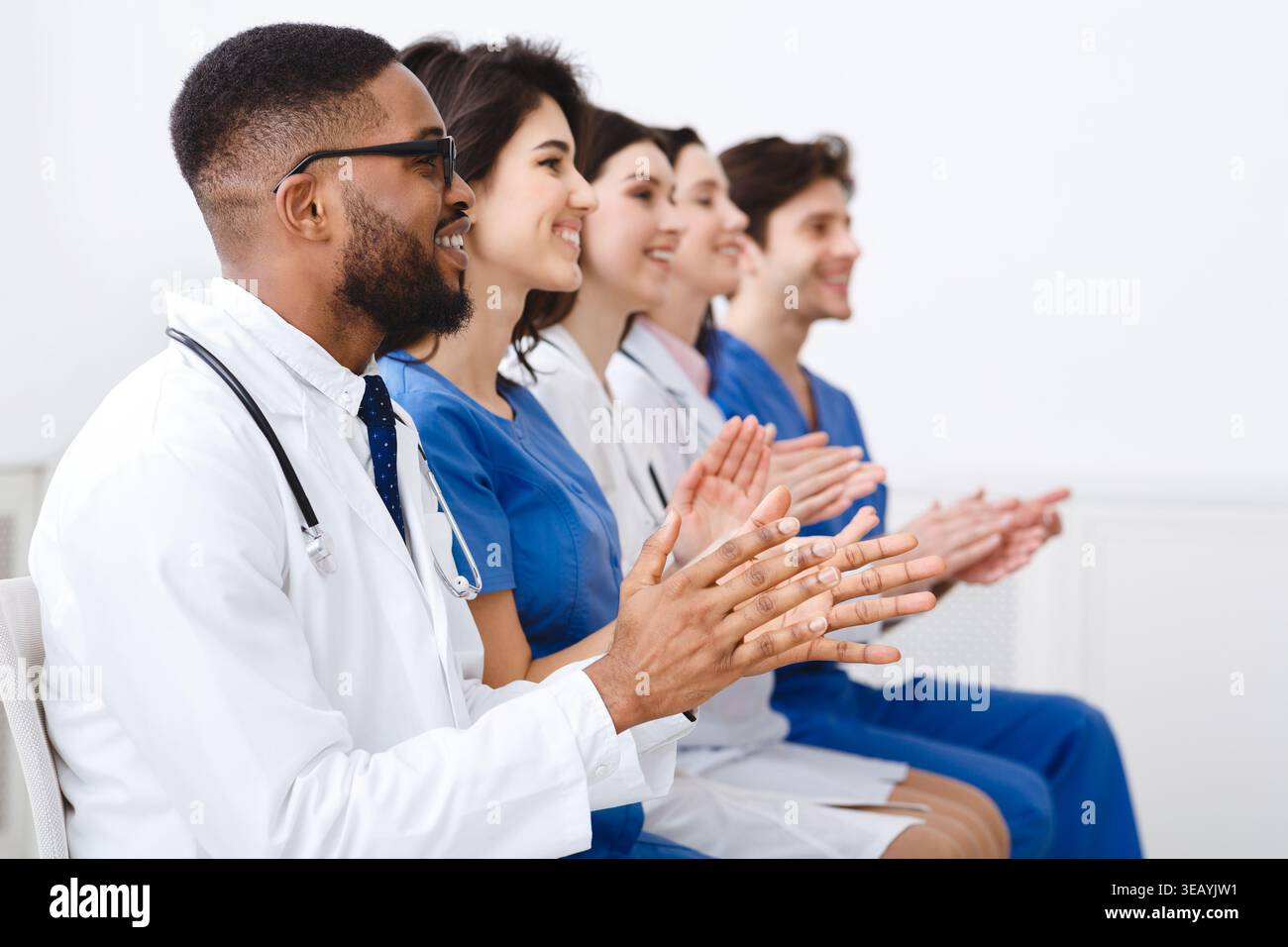 Ärzte und Praktikanten Händeklatschen bei der Konferenz Stockfoto