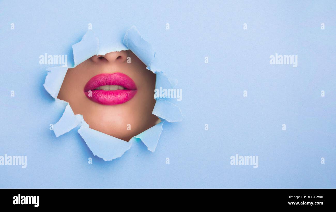 Collage aus Lippen durch gerissenes Papier vor blauem Hintergrund, die Kreativität im Design unterstreicht Stockfoto