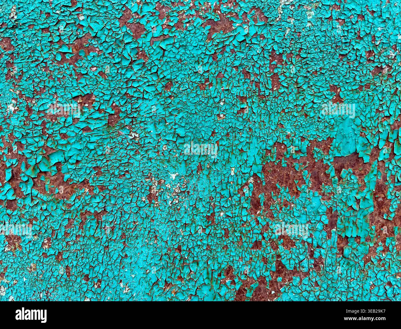 Struktur der Körnung. Gerissene türkisfarbene Farbe mit Rostflecken, robuste Textur in Nahaufnahme. Stockfoto