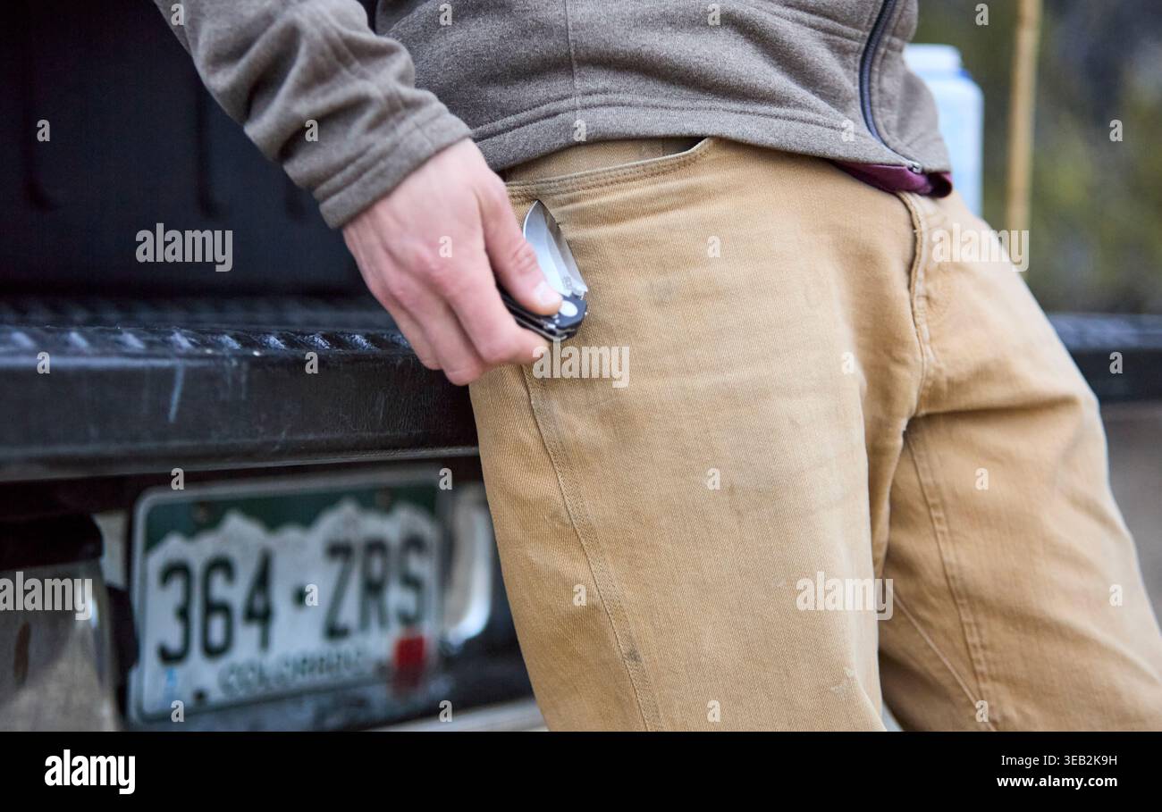 Mann, der jeden Tag ein Taschenmesser in die Hosentasche steckt Stockfoto
