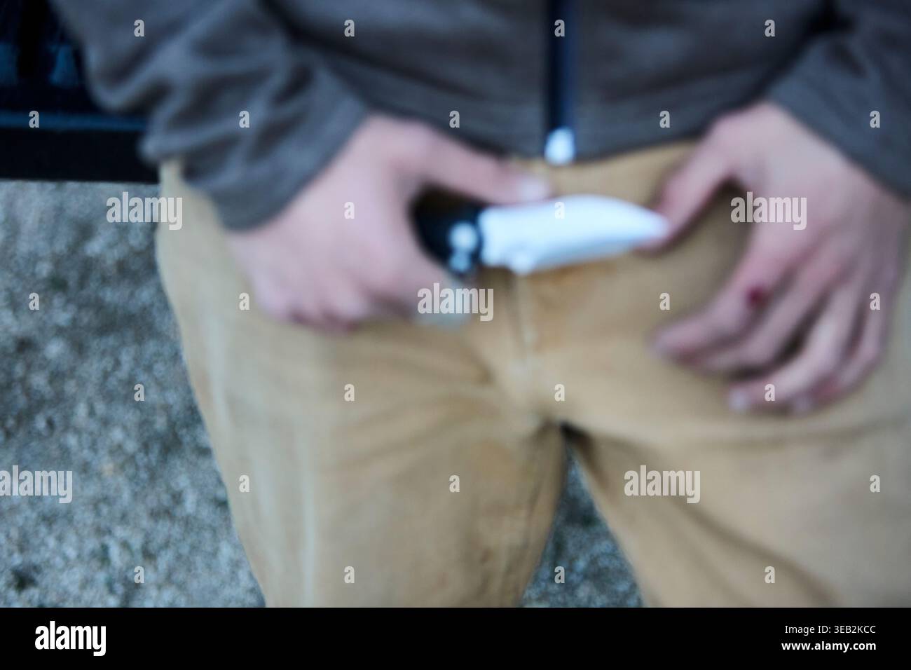 Mann, der ein scharfes Messer mit einem blutenden Finger hält Stockfoto