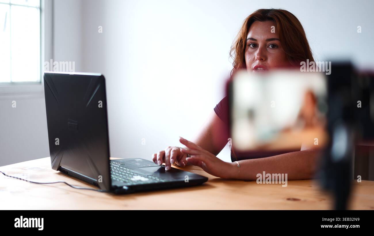 Frau erstellt Online-Videoinhalte, Live-Streaming auf Smartphone mit Laptop Stockfoto