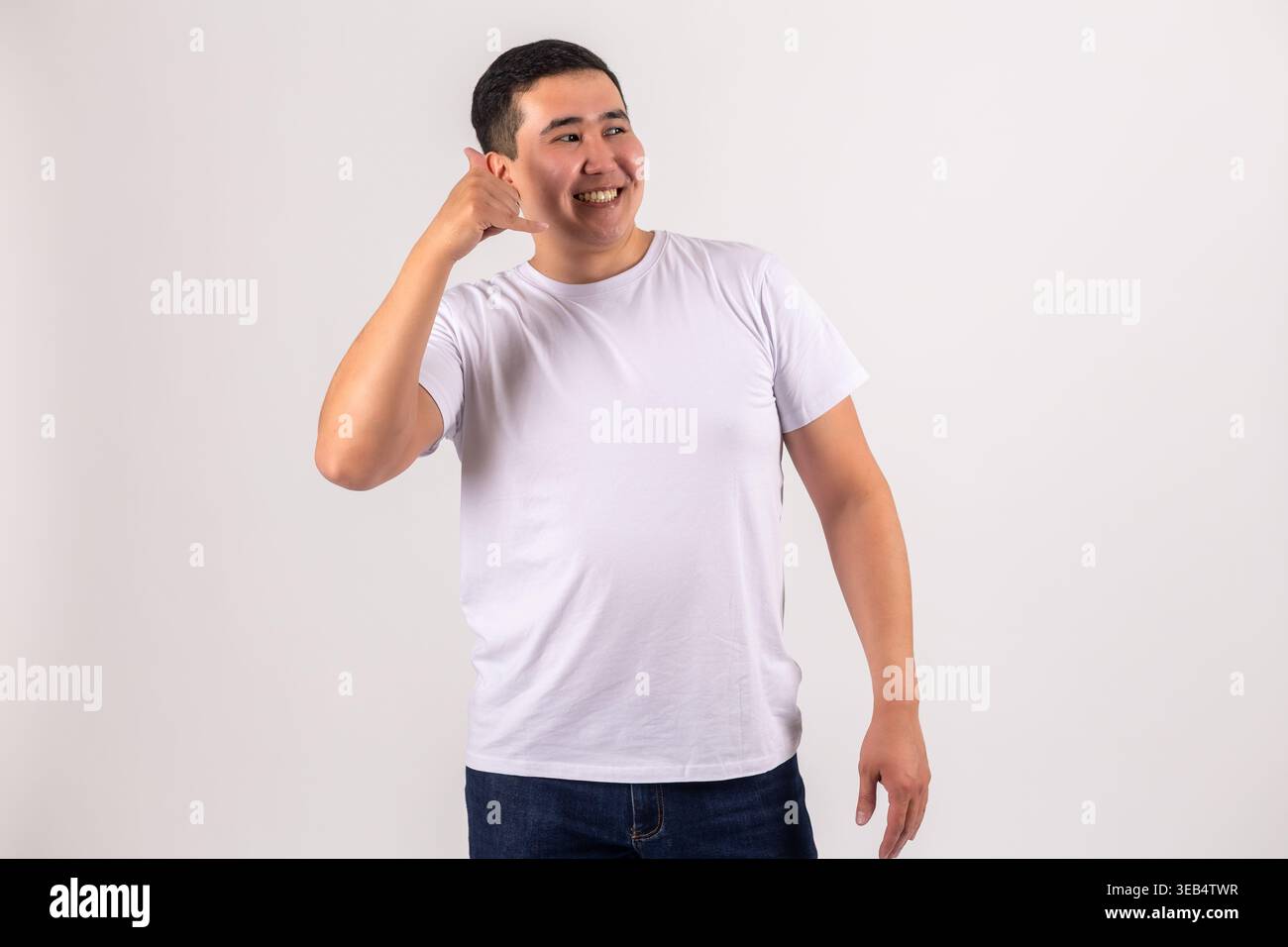 Ein Mann, der mich anrufen will, mit der Hand nahe seinem Ohr Stockfoto