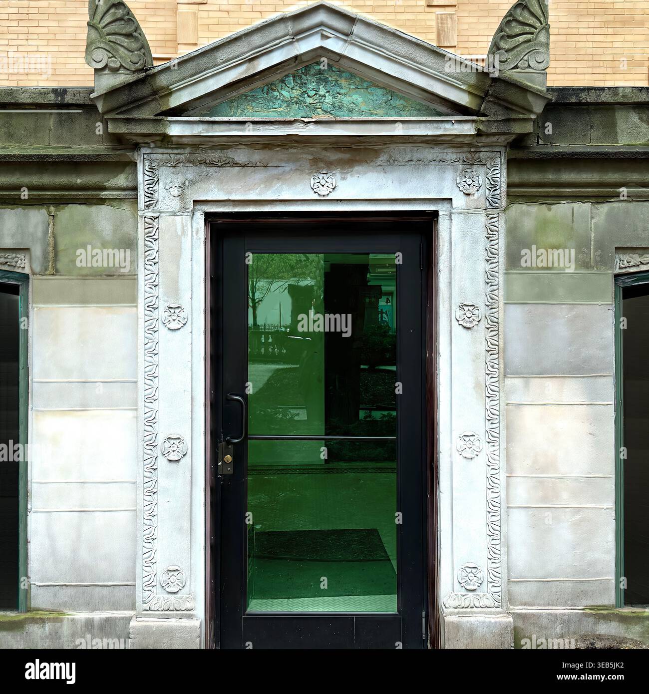 Grüne Glastäfelung mit dreieckigem Giebel und dekorativem Steinrahmen in Chicago Wohnarchitektur Stockfoto