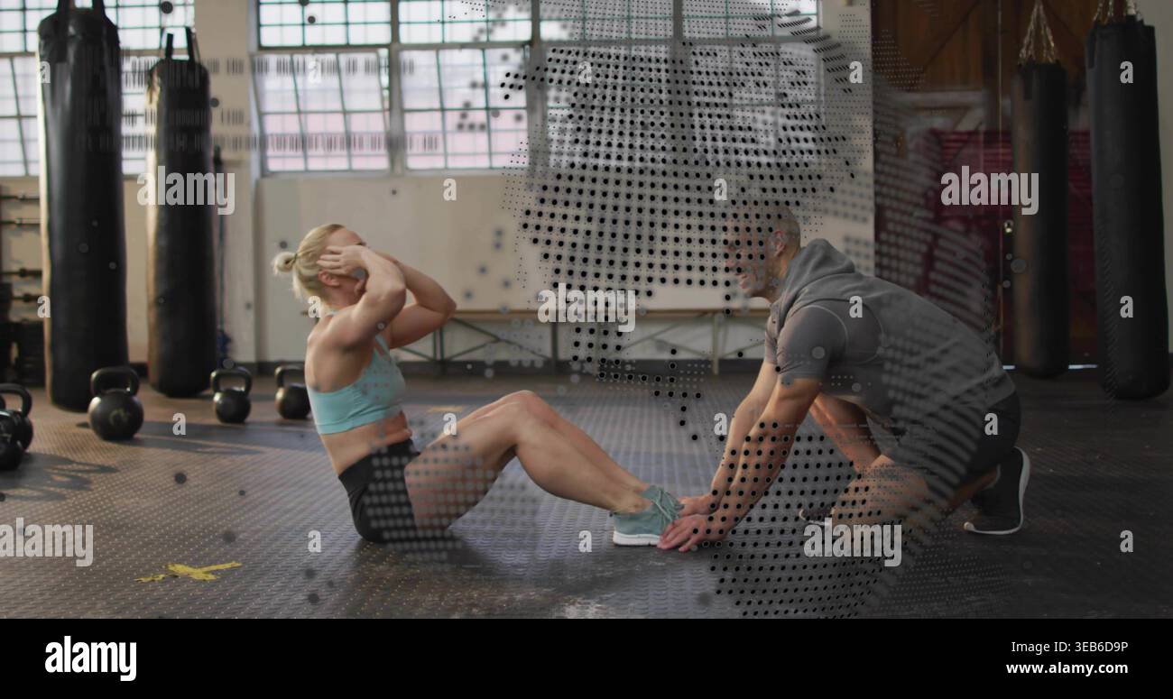 Frauen mit hellblauem BH und schwarzen Shorts im Fitnessstudio, in Kettlebells und Taschen Stockfoto