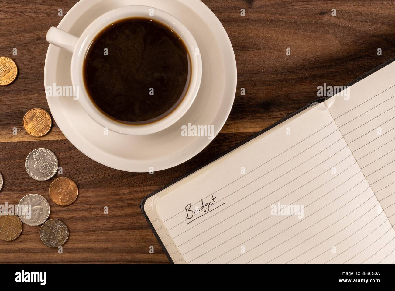 Offenes Notizbuch mit „Budget“ auf Page, Coins and Coffee – Personal Finance Concept Stockfoto