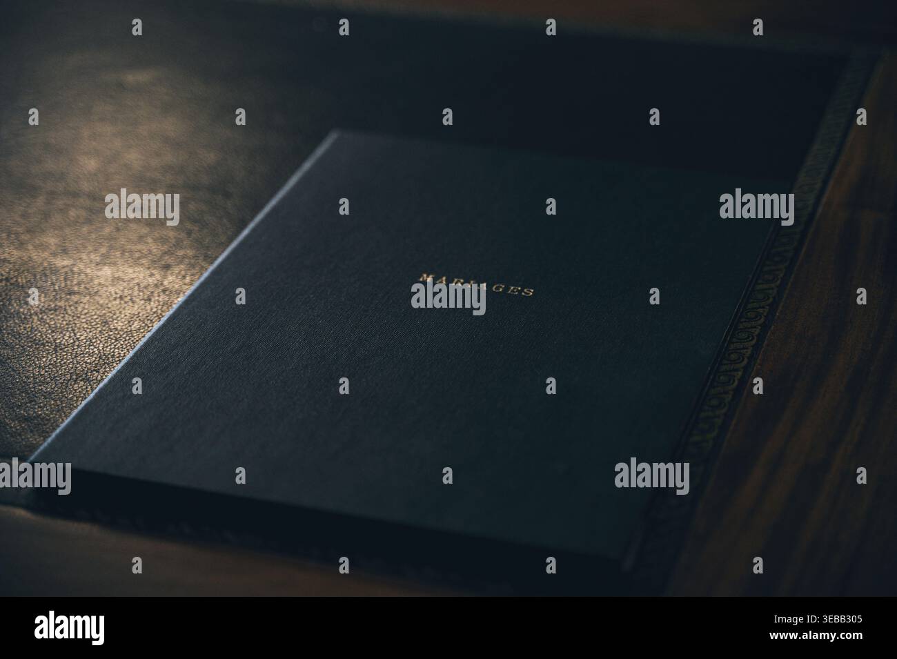 Schwarzes Luxusbuch mit dem in Gold geprägten Wort „MARIAGES“ auf dem Umschlag. Stockfoto
