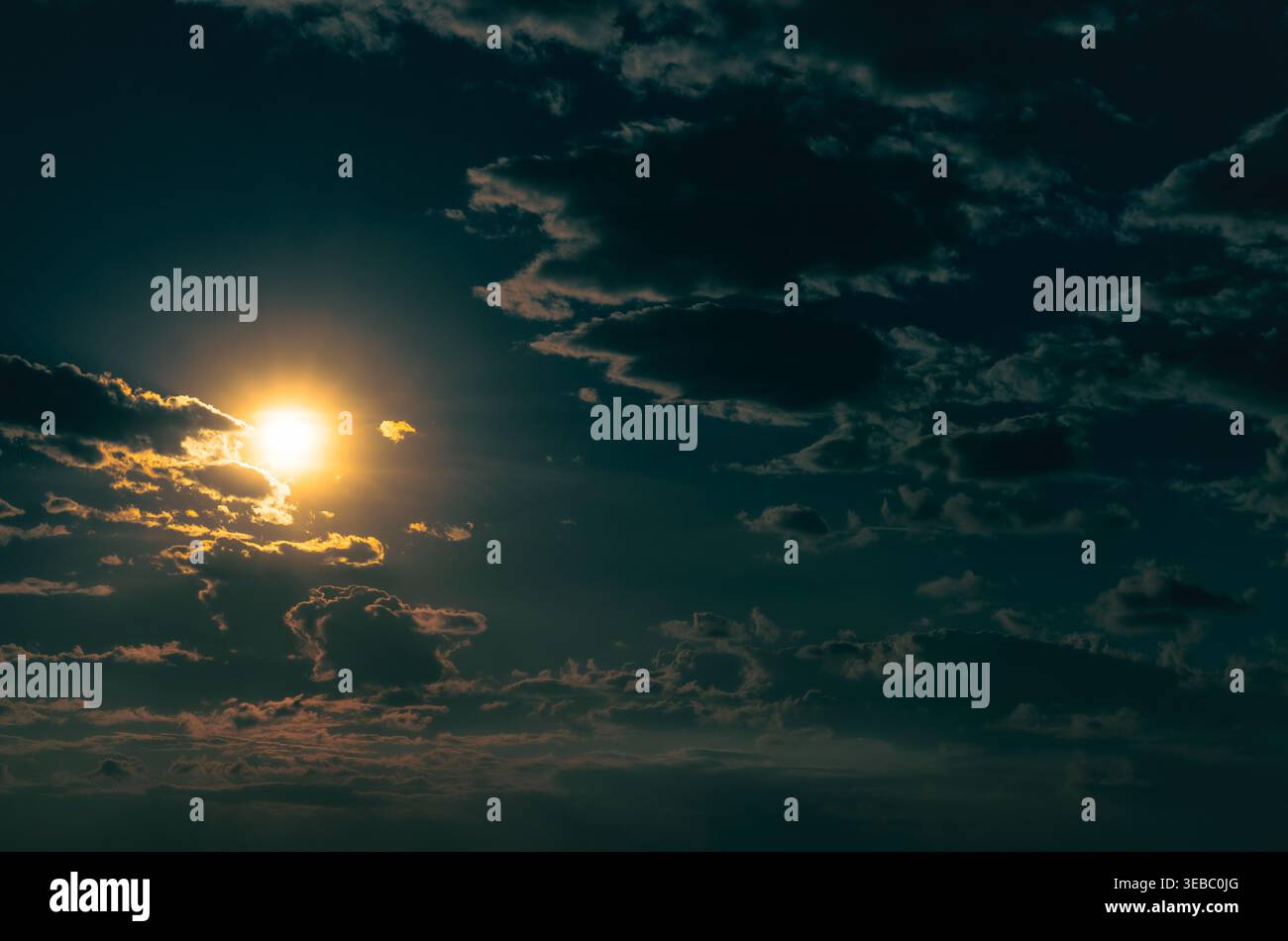 Dramatischer Abendhimmel. Die Sonne scheint durch die Wolken. Stockfoto