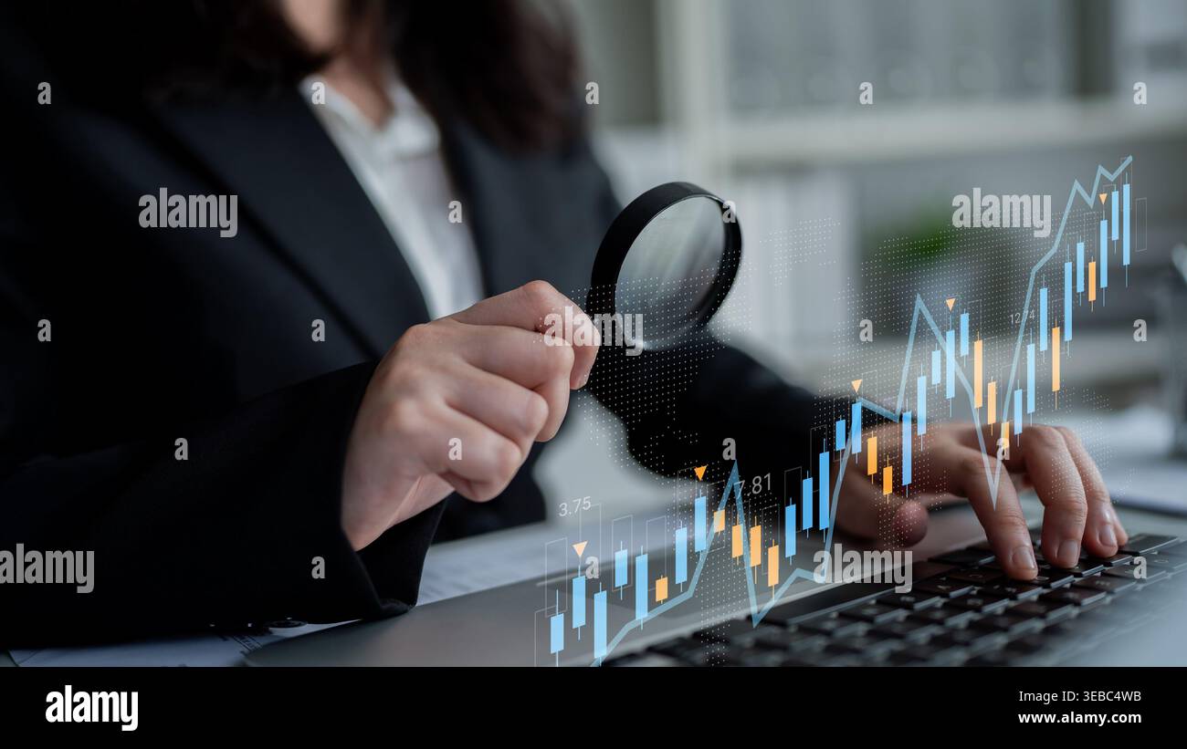 Ein Geschäftsexperte analysiert Finanzdaten mithilfe einer Lupe auf einem Notebook und zeigt die kritische Natur von Marktforschung und Investitionen Stockfoto
