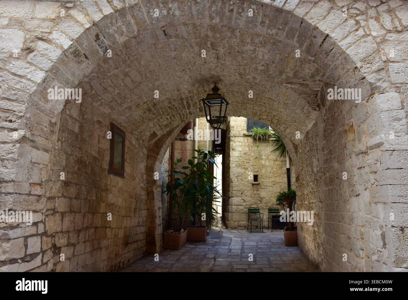 Historischer Steinbogengang mit Pflanzen in der Altstadt von Giovinazzo Italien Stockfoto