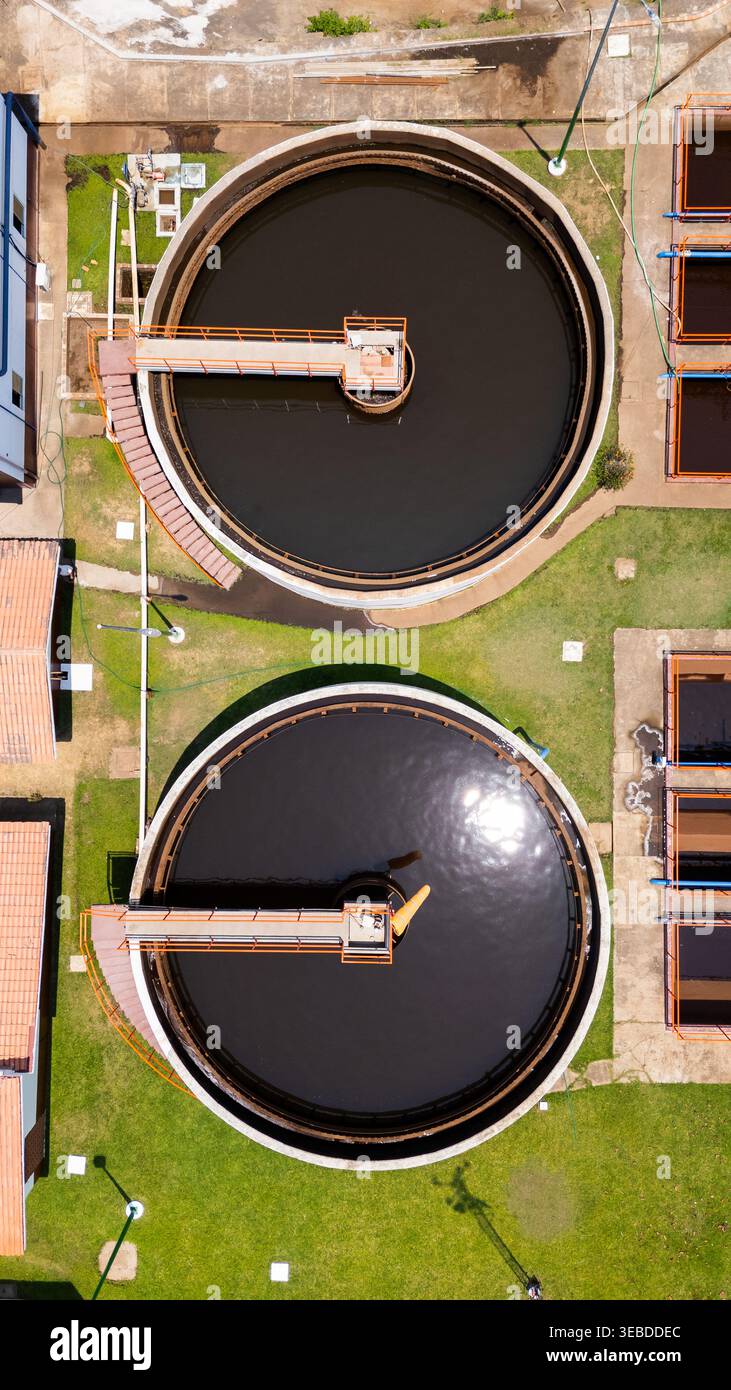 Blick aus der Vogelperspektive auf zwei große kreisförmige Wasseraufbereitungstanks mit orangefarbenen Gehwegen, umgeben von grünem Gras und Industrieanlagen Puerto Vallarta, Jali Stockfoto