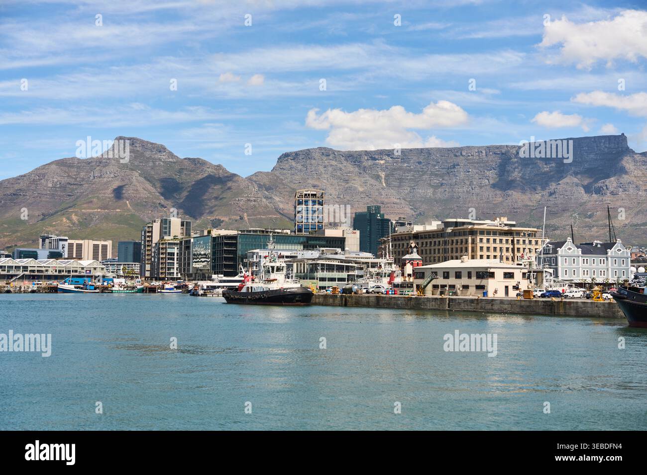 Lebendiger Hafen Mit Bergblick. Lebhafte Hafengegend Mit Farbenfrohen Schiffen Und Bergkulisse Stockfoto